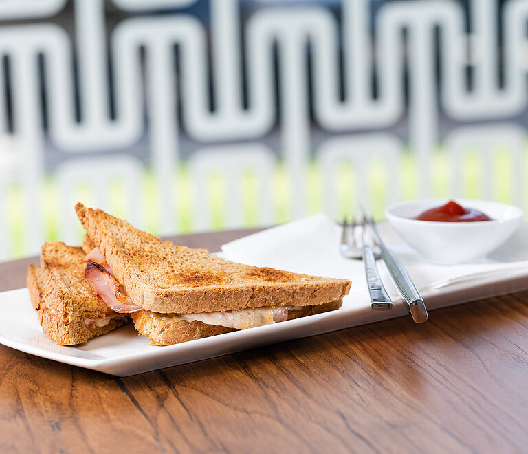 Toast auf einem weißen Teller mit Besteck und Ketchup